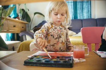 Mädchen malt mit Pinsel auf Papier mit Aquarellfarben zu Hause - ASHF00026