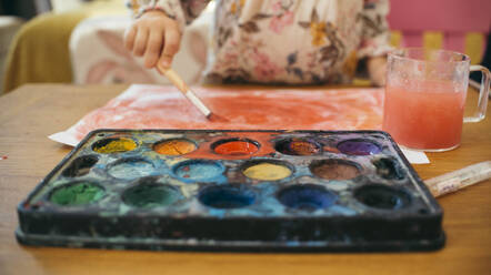 Mädchen malt zu Hause mit Wasserfarben auf Papier - ASHF00029