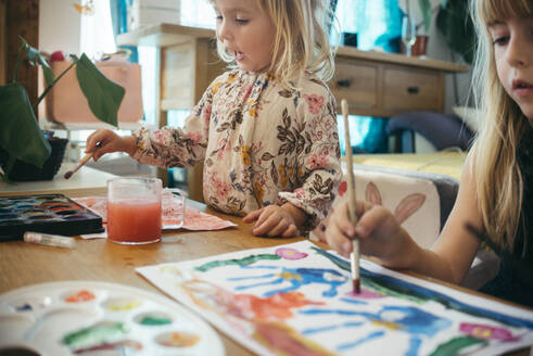Mädchen, die zu Hause mit Pinseln und Wasserfarben malen - ASHF00030