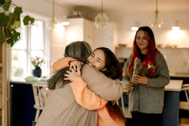 Happy girl embracing grandmother and greeting at home - MASF40598