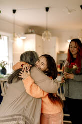 Cheerful girl embracing grandmother and greeting at home - MASF40599