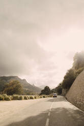 Ein Lieferwagen fährt an einem klaren Tag durch malerische Berge - MASF40746
