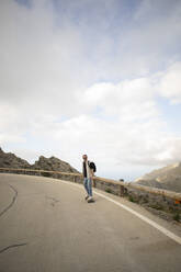 Mature man skateboarding on road against sky - MASF40749