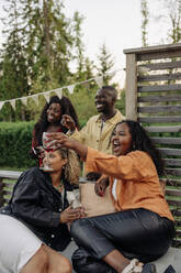 Friends enjoying drinks and good company in a cozy backyard ambiance. - MASF40911