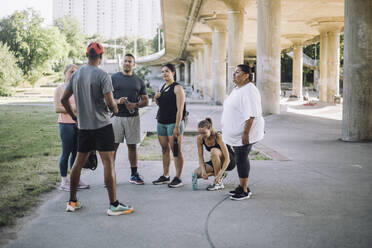 Ein engagierter männlicher Fitnesstrainer motiviert und unterstützt sein Team bei einer intensiven Trainingseinheit - MASF40952