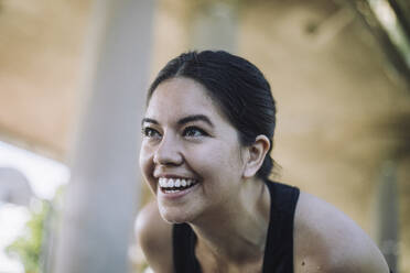 Eine Frau lächelt zufrieden, als sie ihr Training beendet und den Rausch der Endorphine und das Gefühl des Erfolgs verspürt - MASF40970