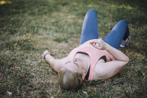 Fatigued woman finds solace amidst the verdant park, taking respite from the hectic pace of life - MASF40982