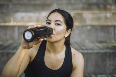 Portrait of woman drinking water from bottle - MASF41014