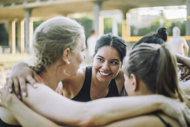 Eine Gruppe von Frauen teilt einen Moment der Freude und Freundschaft, zusammengekauert mit strahlendem Lächeln. - MASF41053