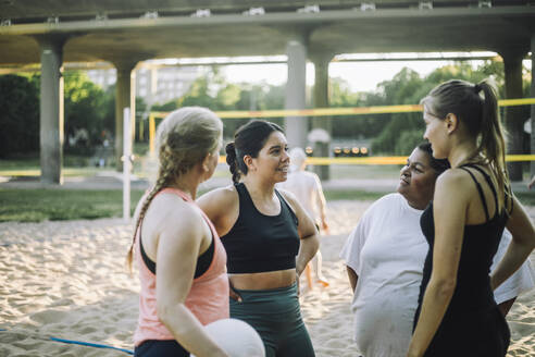 Eine Gruppe von Frauen mit unterschiedlichem Hintergrund, die am Strand ein freundschaftliches Volleyballspiel spielen - MASF41054