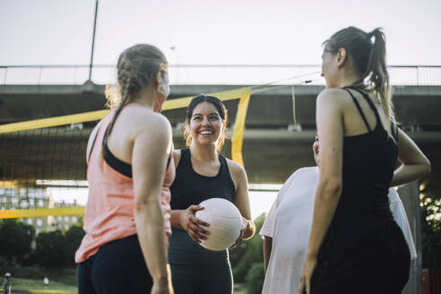 Eine Gruppe von Frauen wirft sich mit einem Volleyball in Pose, eine von ihnen lächelt strahlend, in einer Aufnahme aus geringer Entfernung - MASF41055