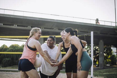 Eine Gruppe von Frauen genießt ein Volleyballspiel und baut durch Lachen und Teamwork Kameradschaft auf - MASF41064