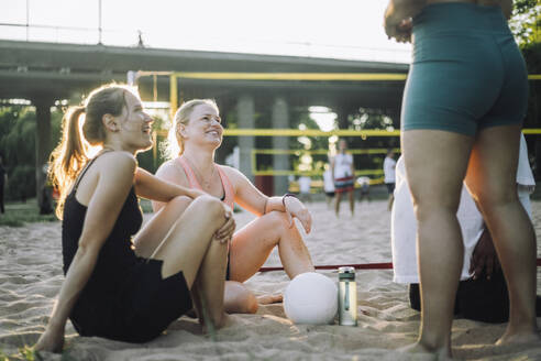 Eine Gruppe fröhlicher Frauen spielt ein freundschaftliches Volleyballspiel und genießt die Gesellschaft der anderen - MASF41068