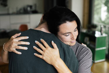 A mother and son share a tender moment of love and comfort in the cozy confines of their home - MASF41088