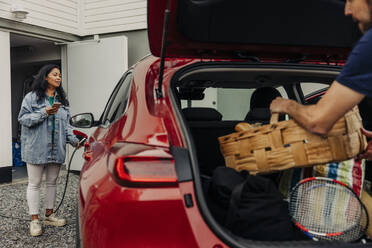 Diese Frau lädt ihr Elektroauto bequem mit ihrem Smartphone auf und setzt damit auf einen umweltfreundlichen und effizienten Transport - MASF41206