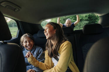 Zwei Schwestern, die zusammen in einem Auto sitzen und lachen und sich gegenseitig begleiten, schaffen einen herzerwärmenden Moment - MASF41231