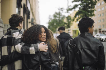 Ein Teenager und ein Mädchen schlendern die Straße hinunter und teilen einen Moment der Freundschaft und Kameradschaft - MASF41251