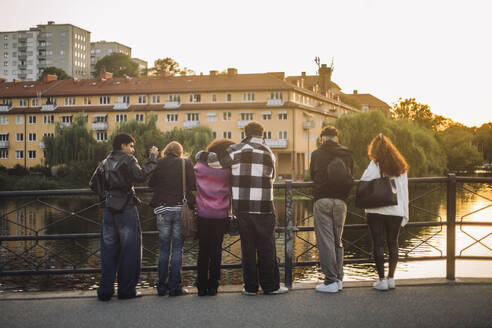 Zwei Freunde genießen den Sonnenuntergang von einem Balkon aus - MASF41342