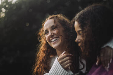 Two friends share a moment of joy as they laugh together. - MASF41346