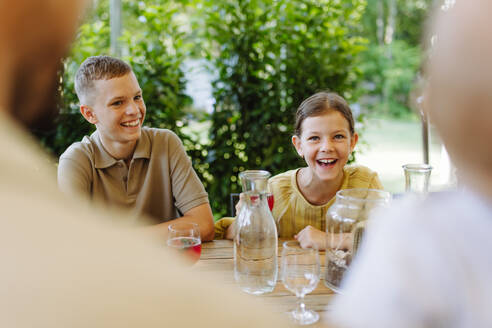 Glückliche Kinder und Eltern, die sich beim Essen in einem gemütlichen, familienfreundlichen Restaurant treffen - HPIF31778