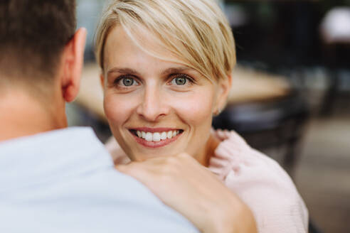 Ein hübsches Paar, das einen intimen Moment auf einer Restaurantterrasse verbringt, die Stirn berührt und ein romantisches Date genießt - HPIF31807