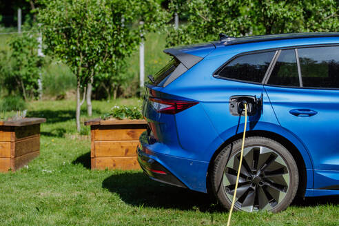 Close-up of an electric car charging in a residential garden. - HPIF31815