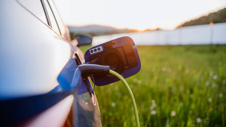 A close-up of an electric car charging, promoting eco-friendliness and sustainable energy. - HPIF31869