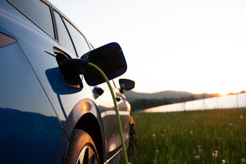 Nahaufnahme eines Elektroautos beim Aufladen, das für Umweltfreundlichkeit und nachhaltige Energie wirbt. - HPIF31870