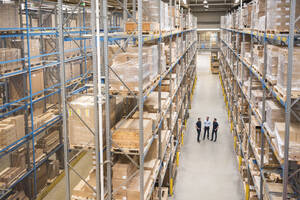 Businessman with colleagues having discussion in warehouse - DIGF21006