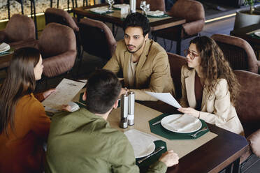 Geschäftskollegen diskutieren über die Speisekarte im Restaurant - DSHF01376