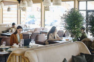 Geschäftsfrau mit Laptop am Tisch in einem Cafe - DSHF01394