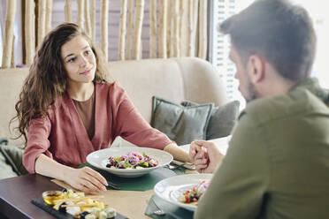 Verliebtes Paar hält sich an den Händen und isst im Restaurant zu Mittag - DSHF01404