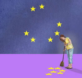 Frau kehrt von der Flagge der Europäischen Union heruntergefallene Sterne auf - GWAF00420