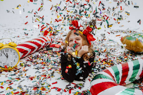 Happy girl lying on floor with Christmas decoration - MDOF01741