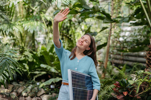 Junge Frau im botanischen Garten mit einer Photovoltaikanlage. - HPIF31899