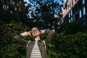 Portrait of young woman enjoying nature in a city park. - HPIF31957