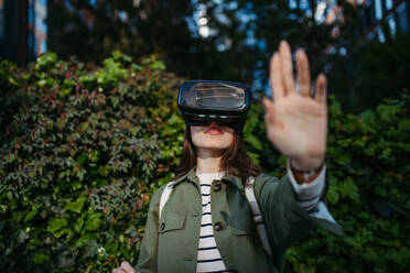 Portrait of happy woman with virtual reality goggles outdoor. - HPIF31962