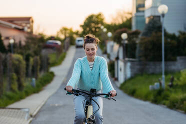 Young woman on an electro bicycle, concept of commuting and ecologic traveling. - HPIF31992