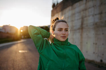 Young woman in sportive clothes resting outdoor during sunset. - HPIF31996