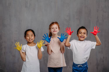 Portrait of happy kids with painted hands, studio shoot. - HPIF32046