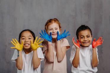 Portrait of happy kids with painted hands, studio shoot. - HPIF32047