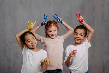 Portrait of happy kids with painted hands, studio shoot. - HPIF32050