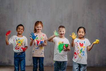 Portrait of happy kids with finger colours and painted t-shirts. - HPIF32057