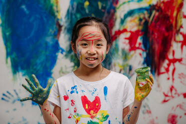 Portrait of happy kid with finger colours and painted t-shirts. - HPIF32064