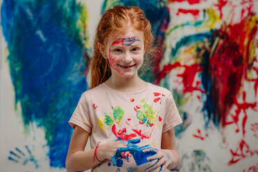 Portrait of happy kid with finger colours and painted t-shirts. - HPIF32065