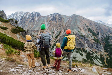 Rückansicht einer Familie mit kleinen Kindern bei einer Herbstwanderung in den Bergen, Konzept der gesunden Lebensweise. - HPIF32104