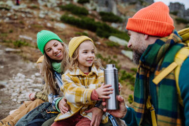 Happy family resting, having snack during hiking together in an autumn mountains. - HPIF32108