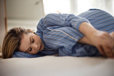 Young woman lying alone in a bed, concept of mental health. - HPIF32248