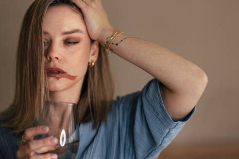 Portrait of depressed woman with a glass of wine. - HPIF32257