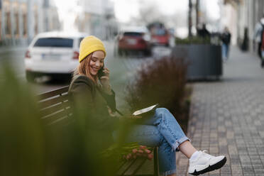 Young woman sitting in a city with tulips and digital tablet. - HPIF32269